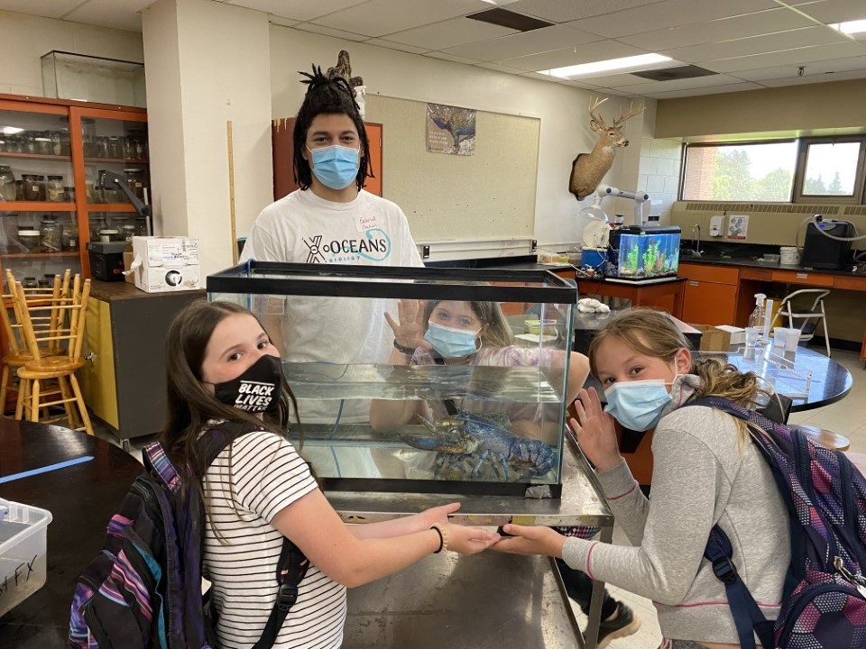 Students Around a Pond of a Blue Lobster