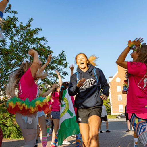 Student with a Hoodie Running While Other Students Cheer