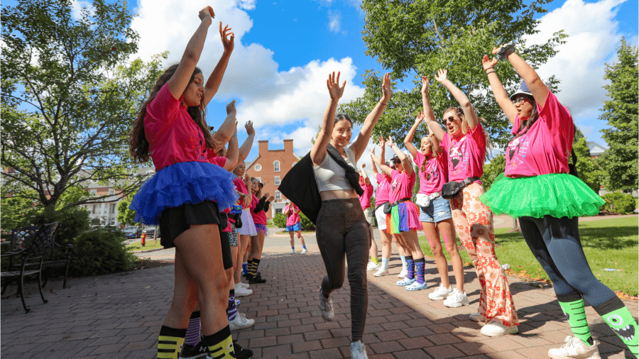 New student runs through Welcome Tunnel at St. Francis Xavier University in Nova Scotia, greeted by cheering upper-year students in colourful outfits