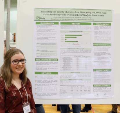 Student standing with their project