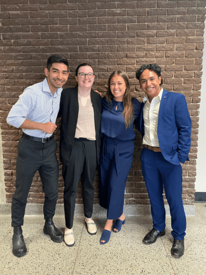 A group of four business students standing together